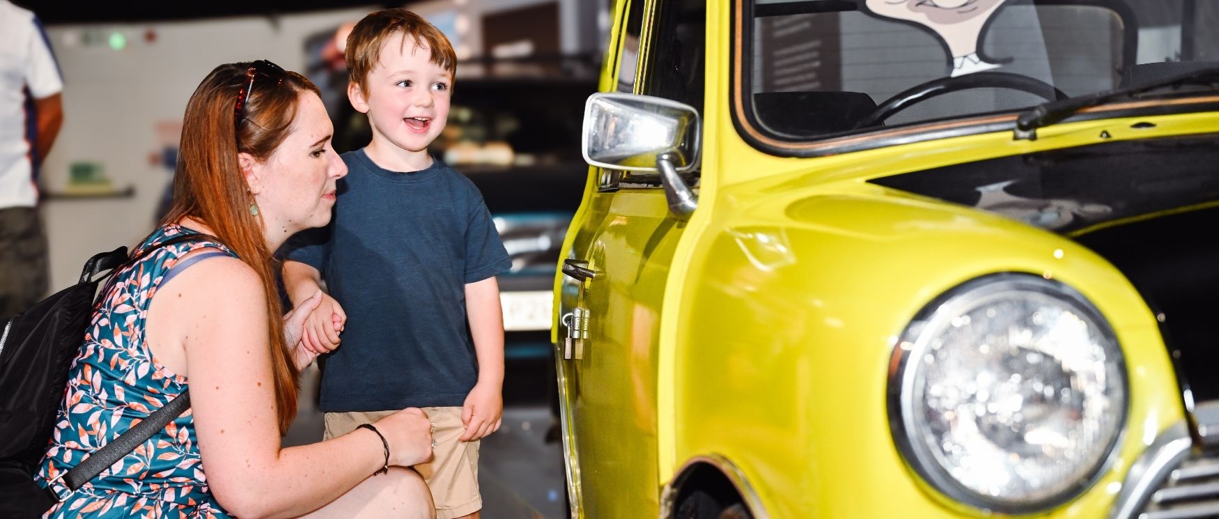 A child and adult in summer clothes stand beside Mr Bean's car at Beaulieu A child and adult in summer clothes stand beside Mr Bean's car at Beaulieu